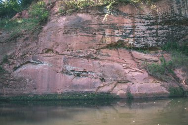 kumtaşı kayalıklarla nehrin Amata ve yeşil ormanlar, Letonya, sahilinde