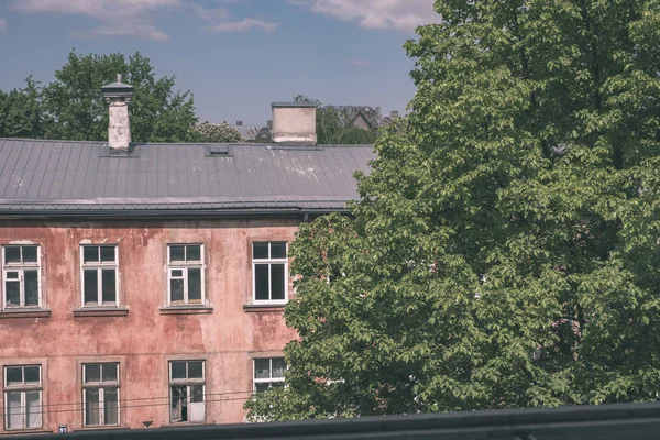 view of old shabby pink building in city in sunny day