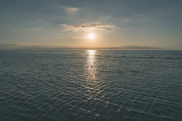 deniz parlak renkler ve dramatik bulutlar üzerinde renkli günbatımı