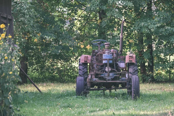 Régi Traktor Gumiabroncs Zöldellő Udvarban — Stock Fotó