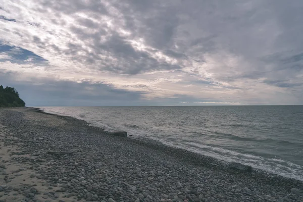 美しい曇り空の下で空の小石の海ビーチ — ストック写真