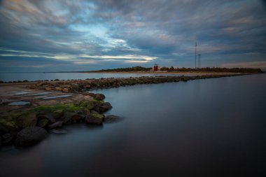Pier deniz gün batımında bulutlu gökyüzü altında