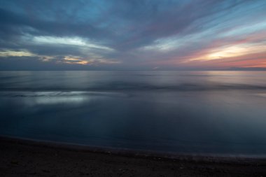 güzel dramatik yüksek karşıtlık bulutlar deniz üzerinde gün batımında