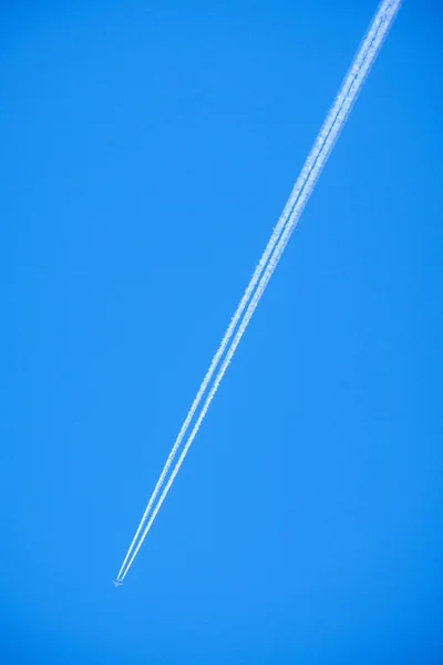 plane white smoke trail on bright blue sky