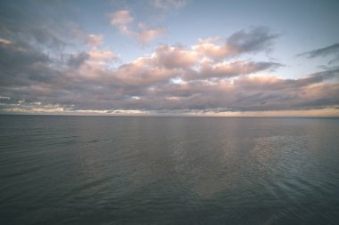 Yaz aylarında sakin su üzerinde mavi gökyüzü