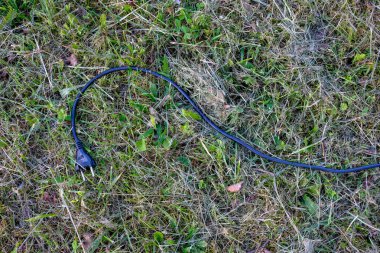 yeşil çimenlerin üzerinde Döşeme siyah elektrik tel 