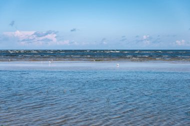 Yaz aylarında sakin su üzerinde mavi gökyüzü