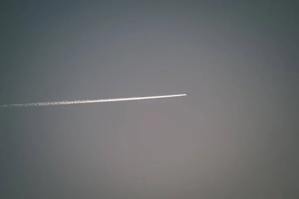 平面と青い空に白い煙のトレイル — ストック写真