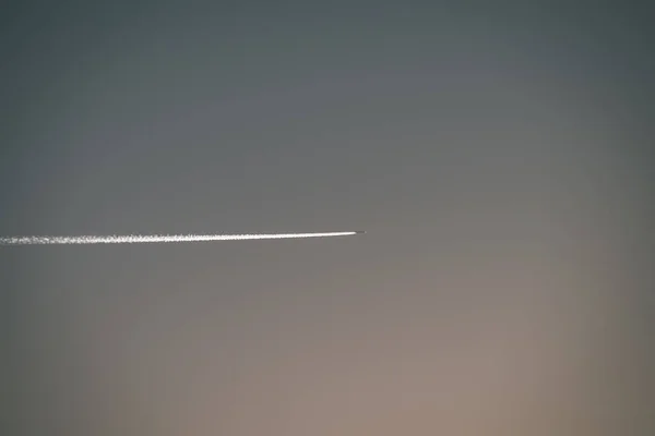 平面と青い空に白い煙のトレイル — ストック写真