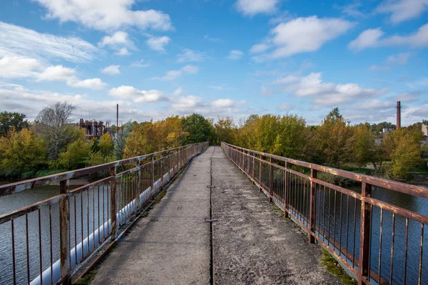 scenic view of empty bridge, trees and blue sky in Latvia