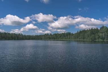 Yaz aylarında sakin su üzerinde mavi gökyüzü