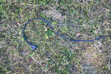 yeşil çimenlerin üzerinde Döşeme siyah elektrik tel 