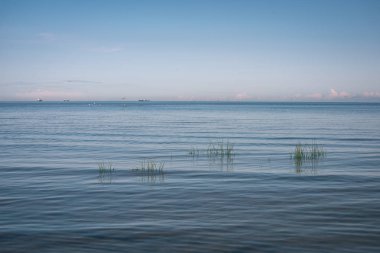 Yaz aylarında sakin su üzerinde mavi gökyüzü