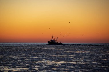 Dondurulmuş deniz üzerinde kırmızı günbatımı manzaralı görünüm