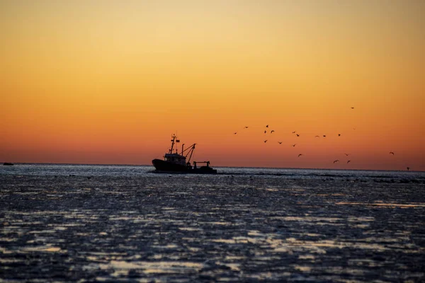 Dondurulmuş deniz üzerinde kırmızı günbatımı manzaralı görünüm