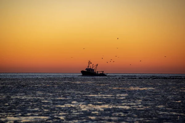 Dondurulmuş deniz üzerinde kırmızı günbatımı manzaralı görünüm