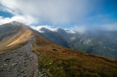 Slovakça Tatra Dağları'nda bulutların üzerinde yürüme. sisli sonbahar sabahı turistik rotalar taşlarla işaretlenmiş