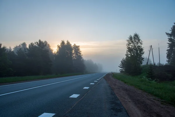 空旷的柏油路与白色的线条画在雾蒙蒙的7月上午 — 图库照片