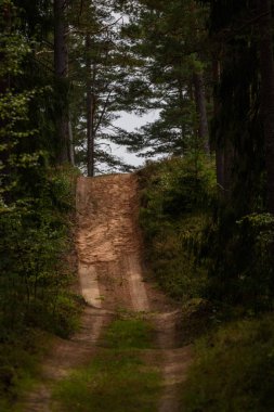 boş ülke stabilize yol çamur ile su birikintileri ve darbelere. kirli yol yüzeyi kum ve küçük taşlarla