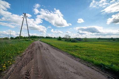 boş ülke stabilize yol çamur ile su birikintileri ve darbelere. kirli yol yüzeyi kum ve küçük taşlarla