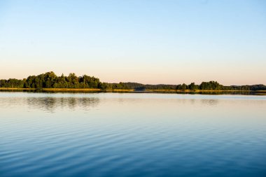 Hava günbatımı sakin su ve su sessiz simmetry ve ağaç yansımalar ile ülke göl kenarında sakin