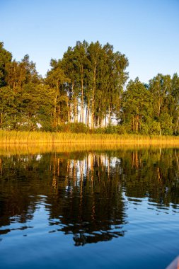 Hava günbatımı sakin su ve su sessiz simmetry ve ağaç yansımalar ile ülke göl kenarında sakin