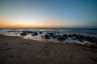 temiz gökyüzü ve sakin su ile yaz aylarında renkli günbatımı deniz sahilde. Baltık Denizi