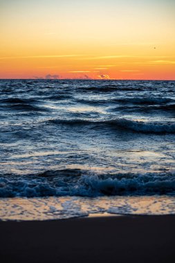 temiz gökyüzü ve sakin su ile yaz aylarında renkli günbatımı deniz sahilde. Baltık Denizi
