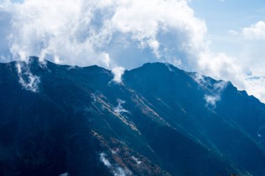 kırık bulutlar ve yaz günü güneş ile mavi gökyüzü arka plan üzerinde Slovakça Tatra mountain yüksek tepeler. turistik rotalar için yürüyüş