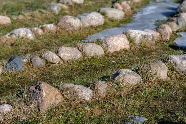 Ornamentos de rocha no prado com água congelada — Fotografia de Stock