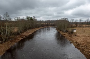 karanlık su ve kirli shore li Letonya, nehir kenarında yatay