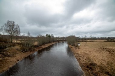 karanlık su ve kirli shore li Letonya, nehir kenarında yatay