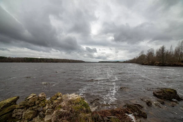 Paisagem ribeirinha em latvia com água escura e li costa suja — Fotografia de Stock