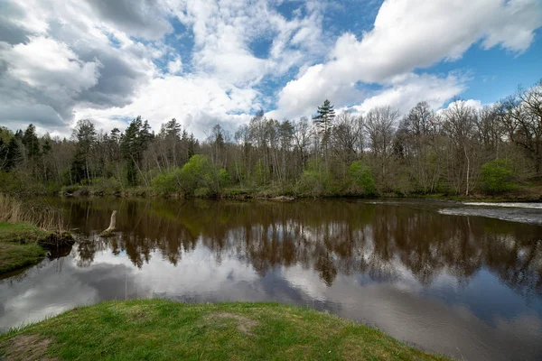 Paisaje junto al río en latvia con agua oscura y costa sucia li —  Fotos de Stock