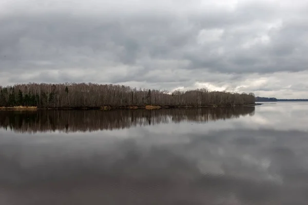 Paesaggio lungo il fiume in latvia con acqua scura e riva sporca li — Foto Stock