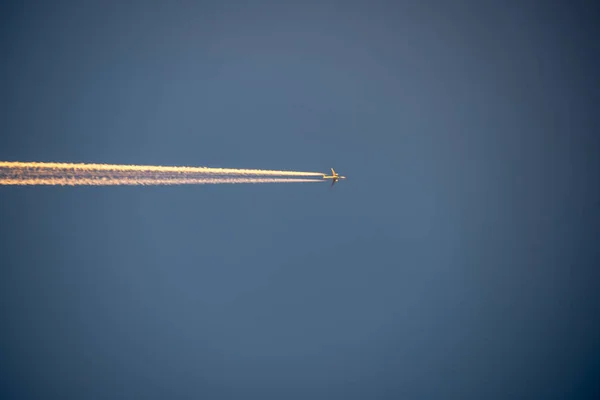 plane leaving smoke trail in the blue sky