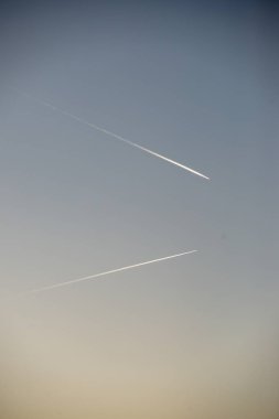 mavi gökyüzünde duman iz bırakarak uçak