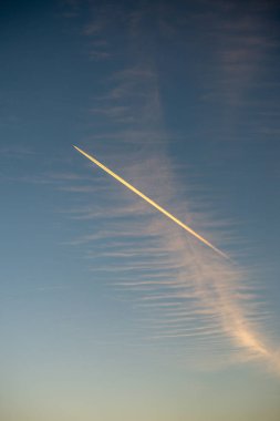 mavi gökyüzünde duman iz bırakarak uçak