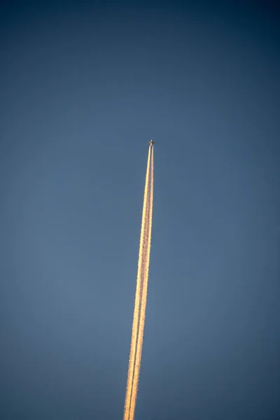 plane leaving smoke trail in the blue sky