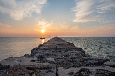 Sakin deniz plaj yaz büyük kayalar ve ahşap direklerin 