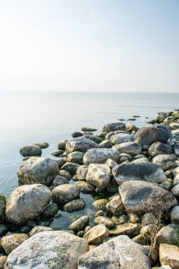 Sakin deniz plaj yaz büyük kayalar ve ahşap direklerin 