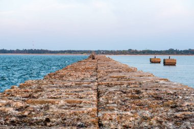 Sakin deniz plaj yaz büyük kayalar ve ahşap direklerin 