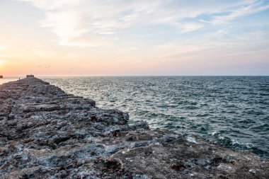 Sakin deniz plaj yaz büyük kayalar ve ahşap direklerin 