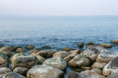 Sakin deniz plaj yaz büyük kayalar ve ahşap direklerin 