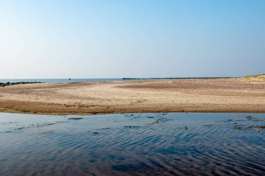 Sakin deniz plaj yaz büyük kayalar ve ahşap direklerin 
