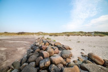 Sakin deniz plaj yaz büyük kayalar ve ahşap direklerin 