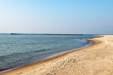 Sakin deniz plaj yaz büyük kayalar ve ahşap direklerin 