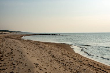 Sakin deniz plaj yaz büyük kayalar ve ahşap direklerin 