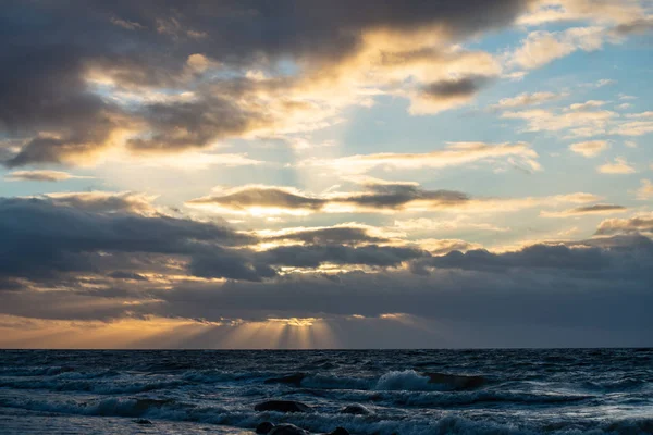 Coucher de soleil spectaculaire sur la plage de mer avec des roches et des eaux orageuses — Photo