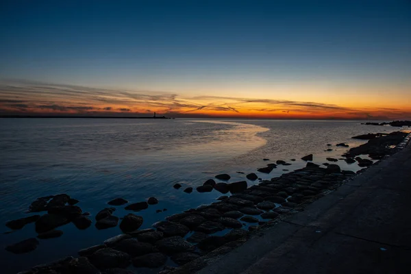 Dramático atardecer sobre la playa de mar con rocas y aguas tormentosas — Foto de Stock